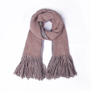 Detailed close-up of double-sided knit scarf with pink and grey colors and long tassels