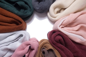 Close-up of thick solid color scarves in multiple shades with fine knit texture