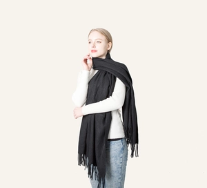 Classic black cashmere feel scarf with fringe tassels shown on a female model