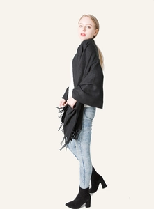 Full view of black pashmina shawl with long fringes styled with jeans and boots