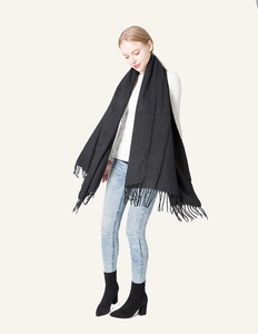 Close-up of black cashmere-like long scarf with fine tassel fringe details and texture