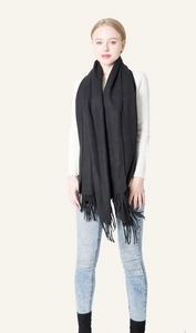 Classic black cashmere-like scarf with fringe details worn by a female model