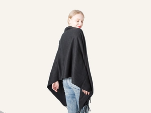 Detail shot of black cashmere-like shawl featuring soft knit texture and fringe hem