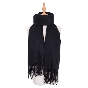 Detail of pure black winter scarf featuring fine tassel fringe and soft knit texture