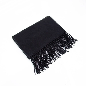 Detail of solid black cashmere-like scarf showing soft woven texture and neat fringe tassels