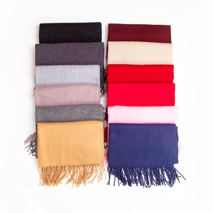 Flat lay of cashmere-like scarves in twelve assorted colors with fringed edges