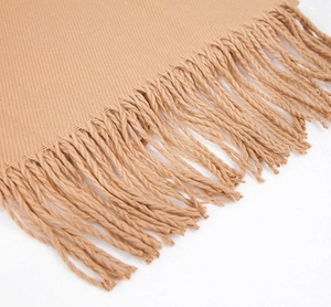 Detail shot of solid camel scarf showing twill weave texture and twisted tassel fringe