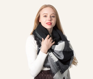 Detail of black and white checkered scarf with fine tassel edges and soft knit texture