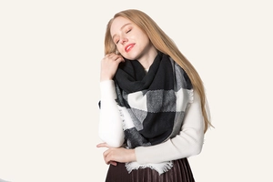 Detail view of the soft black and white buffalo check scarf with delicate fringe edges