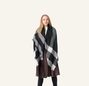 Detail showing the thick black and white plaid scarf texture and short fringe edges