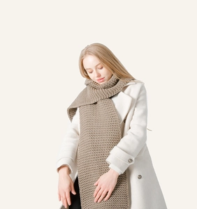 Close-up of thick chunky knit texture on a warm brown winter scarf for men and women