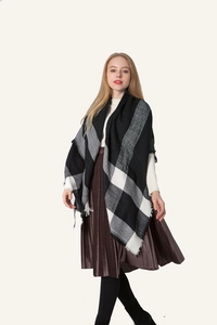Detail shot of the soft fringe edges on a black and white checkered cashmere-like shawl