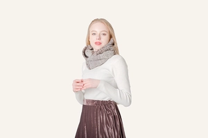 Close-up of knit scarf showing brown mixed textured weave and warm winter material