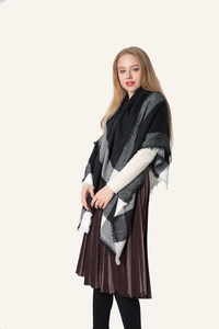 Detail shot of black and white plaid scarf with fringe edges and soft cashmere texture