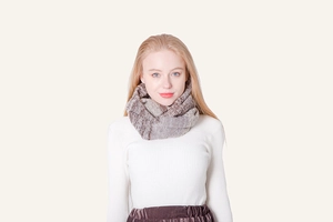 Detail of multi-color striped knitted infinity scarf with brown and grey textures