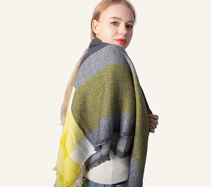 Close-up of yellow and grey plaid cashmere scarf featuring thick knit and fringe edges
