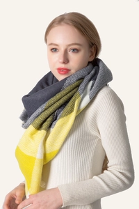 Detail of soft cashmere-like knit scarf featuring yellow and grey color block pattern