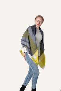 Close-up of thick winter scarf fringe detail with yellow and grey plaid pattern