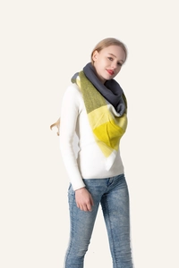 Detail of soft cashmere-feel scarf with yellow and grey plaid pattern worn on white top