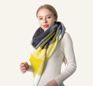 Detail of soft knit yellow and grey checkered scarf showing the cozy texture and pattern