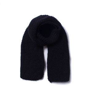 Close-up of thick black chunky knit scarf showing warm texture and ribbed pattern detail