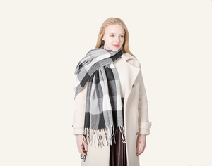 Detail of soft black and white plaid scarf with elegant fringed edges for winter style