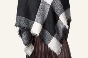 Detailed view of black and white checkered cashmere shawl with stylish fringe tassels