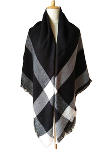 Close-up of winter cashmere scarf featuring black and white check pattern with long tassels