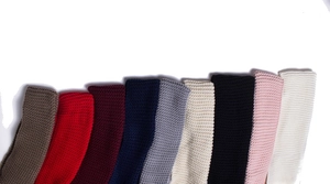 Texture detail of chunky knit scarves in various colors showing thick woven patterns