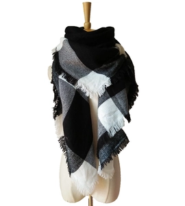 Detailed close-up of thick black and white plaid scarf with decorative fringe texture