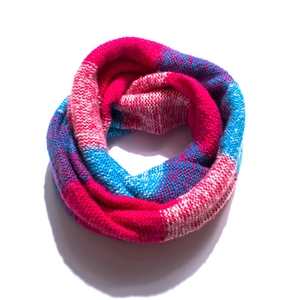 Detail of multi-color knitted infinity scarf with pink, white and blue patterns
