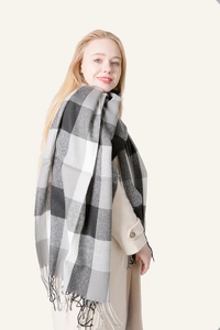 Close-up of a large plaid scarf with fringe edges in black, white and grey tones