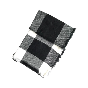 Detail of classic black and white buffalo check pattern scarf with fine fringe edges