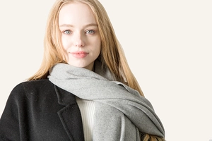 Close-up of soft grey wool scarf with fringe texture worn with a black winter coat