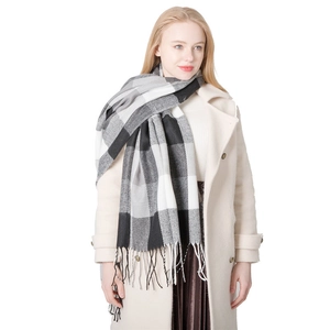 Classic British plaid scarf with tassels styled on a long coat for winter warmth