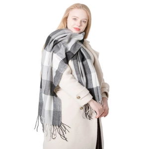 Plaid oversized winter scarf in black and grey with tassels on a classic wool coat