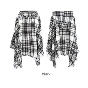 Women's black and white checkered hooded poncho with fringe tassel hem in a flat lay view