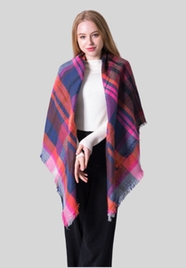 Close-up of colorful checkered cashmere scarf with pink, orange, and blue fringe detail