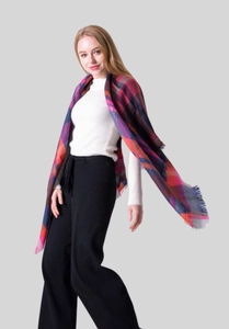 Close-up of vibrant colorful plaid scarf featuring soft fringe and cashmere texture