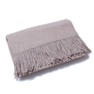 Detail of light taupe wool scarf showing soft knit texture and fringe tassels on white background