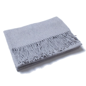 Close-up of a thick dark grey wool scarf featuring dense tassel details on white background