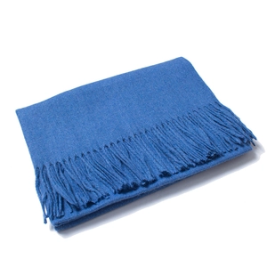 Detailed view of dark blue wool scarf featuring long fringes and soft knit texture