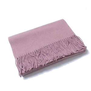 Close-up of the soft lotus pink wool scarf featuring classic thick tassels and knit texture