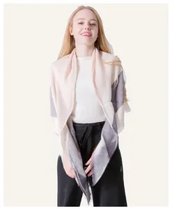 Detailed shot of beige and purple cashmere-style knit shawl with elegant tassel fringe