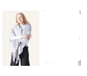 Detail of grey and white checkered cashmere-like scarf with soft fringe edges