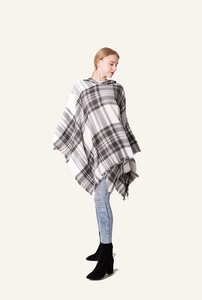 Dettaglio di un poncho con cappuccio da donna con motivo a quadri grigi e frange ai bordi