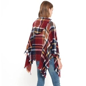 Dettaglio della trama a quadri colorati e frange sulla mantella poncho con cappuccio in cashmere
