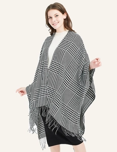 Close-up of classic black and white houndstooth knit fabric and long fringe tassel detail