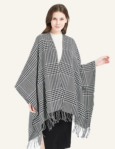 Close-up of houndstooth knit pattern and delicate tassel fringe on an elegant shawl