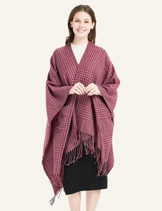 Detail of red and grey houndstooth pattern fabric and tassel fringe on a soft shawl